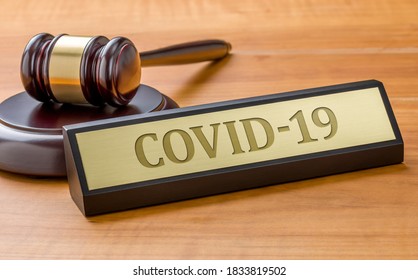 A gavel and a name plate with the engraving COVID-19