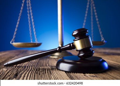 Gavel And Scales Of Justice On Wooden Table And Blue Background