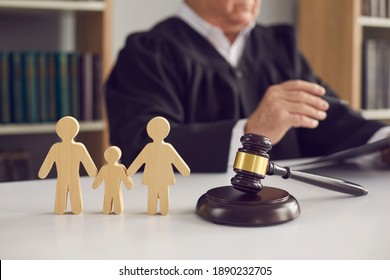 Gavel, Sound Block And Small Wooden Figurines Of Husband, Wife And Kid On Judge's Table In Courthouse During Court Hearing. Family Law, Divorce Lawyer, Joint Custody Of Child And Alimony Concept