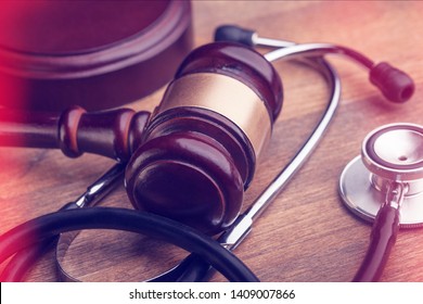 Gavel And Stethoscope On Wooden Background, Symbol Photo For Bungling And Medical Error