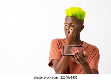 A Gay Black Man Putting On Makeup, LGTBI Concept, Correcting Imperfections On His Face With A Mirror