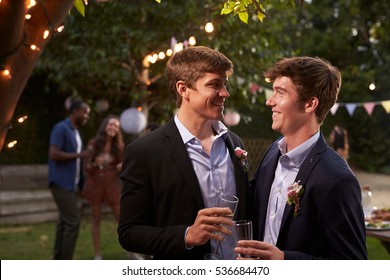 Gay Couple Celebrating Wedding With Party In Backyard