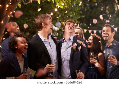Gay Couple Celebrating Wedding With Party In Backyard