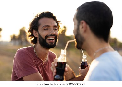 Gay Couple Embracing And Showing Their Love. Young Men Drinking Juice.	