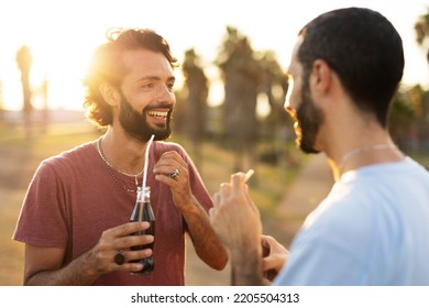 Gay Couple Embracing And Showing Their Love. Young Men Drinking Juice.	