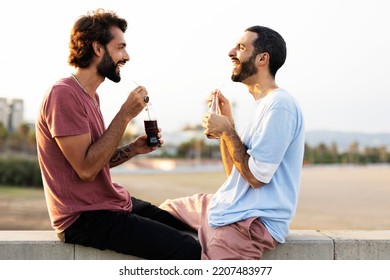 Gay Couple Embracing And Showing Their Love. Young Men Drinking Juice