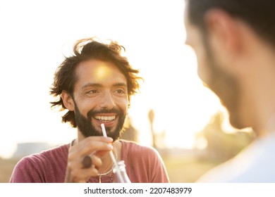 Gay Couple Embracing And Showing Their Love. Young Men Drinking Juice