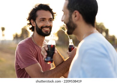 Gay Couple Embracing And Showing Their Love. Young Men Drinking Juice