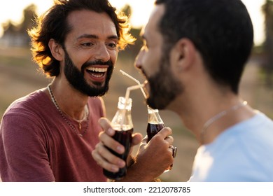 Gay Couple Embracing And Showing Their Love. Young Men Drinking Juice	