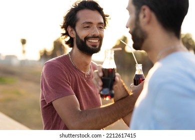 Gay Couple Embracing And Showing Their Love. Young Men Drinking Juice.	