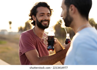 Gay Couple Embracing And Showing Their Love. Young Men Drinking Juice	