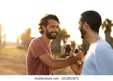 Gay Couple Embracing And Showing Their Love. Young Men Drinking Juice	