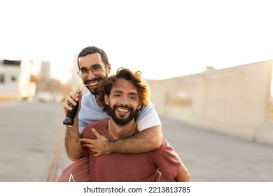 Gay Couple Embracing And Showing Their Love. Young Men Drinking Juice.	