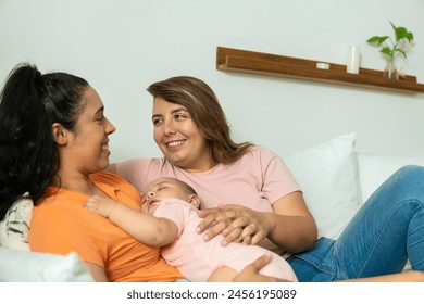 gay couple enjoying time together while baby sleeps in the livin - Powered by Shutterstock