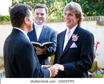 Gay Couple Exchanging Rings And Vows At Their Wedding.