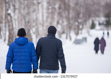 Gay Couple Go Through The Winter Park Holding Hands.