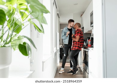 Gay couple having coffee, happy marriage. LGBTQ men cople in kitchen, cozy house interior. Happy gay couple having drinks in kitchen, diverse couple, LGBTQ love concept.  - Powered by Shutterstock