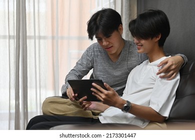 Gay Couple Having Happy Moment And Using A Tablet, LGBT Couples And Everyday Life At Home Concept.