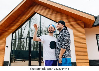 Gay Couple Holding Keys In Hand Buying A New House