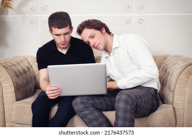 Gay Couple At Home. Two Guys Are Sitting On The Couch.	