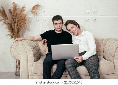 Gay Couple At Home. Two Guys Are Sitting On The Couch.	