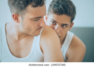 Gay Couple Lying In Bed, Hugging. Men Couple Having Problems, Sad Emotion. LGBT. Homosexual Relationships 