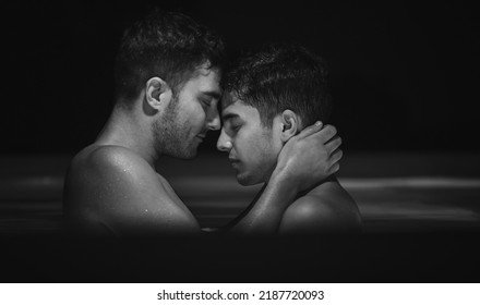 Gay couple relaxing in swimming pool. LGBT. Two young men kissing and hugging. Black and white portrait. Young men romantic family in love. Happiness concept - Shutterstock ID 2187720093