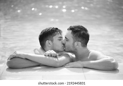 Gay Couple Relaxing In Swimming Pool. LGBT. Two Young Men Enjoying Nature Outdoors, Kissing And Hugging. Young Men Romantic Family In Love. Happiness Concept. Black And White