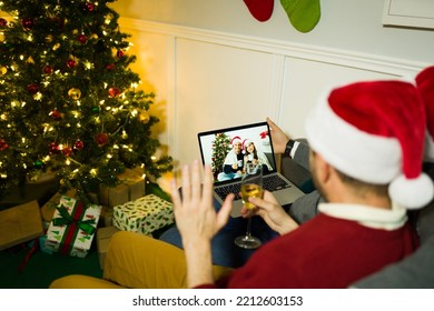 Gay Couple Saying Hi During A Video Call To Family Or Friends While Relaxing During A Christmas At Home