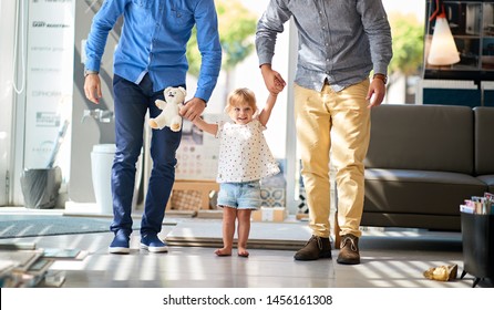 Gay Couple With Smiling Child Girl In Store For Household
