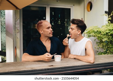 Gay Couple spend time together outdoors. Homosexual couple eating icecream - Powered by Shutterstock