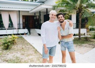 Gay Couple Standing In Front Of Their House And Holding Keys Of Thier New House