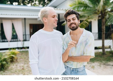 Gay Couple Standing In Front Of Their House And Holding Keys Of Thier New House