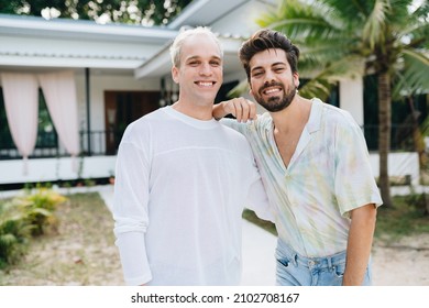 Gay Couple Standing In Front Of Their House And Holding Keys Of Thier New House