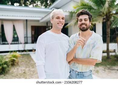 Gay Couple Standing In Front Of Their House And Holding Keys Of Thier New House