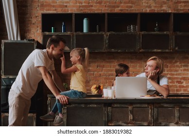 Gay Couple With Their Adopted Cute Daughters Reading Recipe On Laptop And Cooking On Kitchen. Lgbt Family At Home.