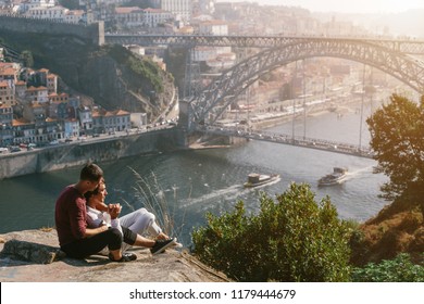 A Gay Couple Traveling And Enjoy Sunset Outdoor, European City View With Bridge And River