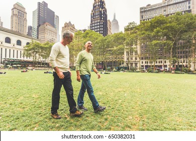 Gay Couple Walking At Park In New York. Two Senior Men Having A Walk Together In New York City. Homosexual Senior Couple Concept