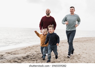 Gay Family Having Fun Together On The Beach In Summer Vacation - LGBT Dads And Sons Lifestyle Concept - Main Focus On Right Man Face