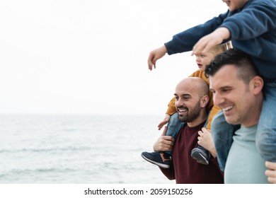 Gay Fathers And Children Playing Outdoor On The Beach - LGBT Family Love Concept - Soft Focus On Left Dad Face