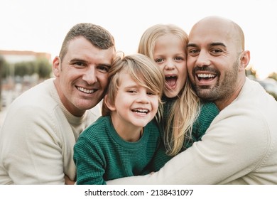 Gay fathers and sons having fun outdoor during summer vacation - LGBT family love concept - Focus on right man face - Powered by Shutterstock