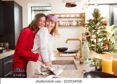 Gay Female Couple At Home In Kitchen Washing Up After Dinner On Christmas Day