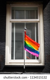 Gay flag on a pole installed on a building exterior in Amsterdam. 