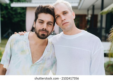 Gay Hugging Couple Standing In Front Of Their House Outdoors