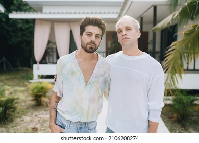 Gay Hugging Couple Standing In Front Of Their House Outdoors