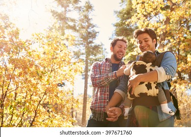 Gay Male Couple With Baby Walking Through Fall Woodland