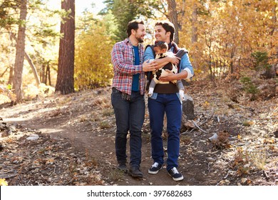 Gay Male Couple With Baby Walking Through Fall Woodland