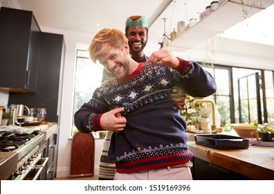 Gay Male Couple At Home In Kitchen Cooking Dinner On Christmas Day Together