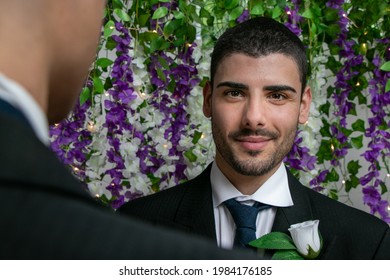 Gay Men Wedding Ceremony With One Groom With Beard Looking At Camera