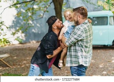 Gay Parents With Their Daughter In The Park. Cute Moments Of A Family Life.